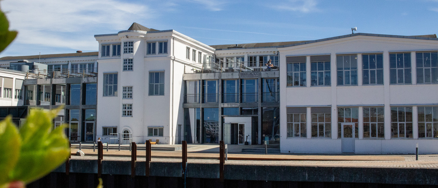 White waterfront building with large windows.