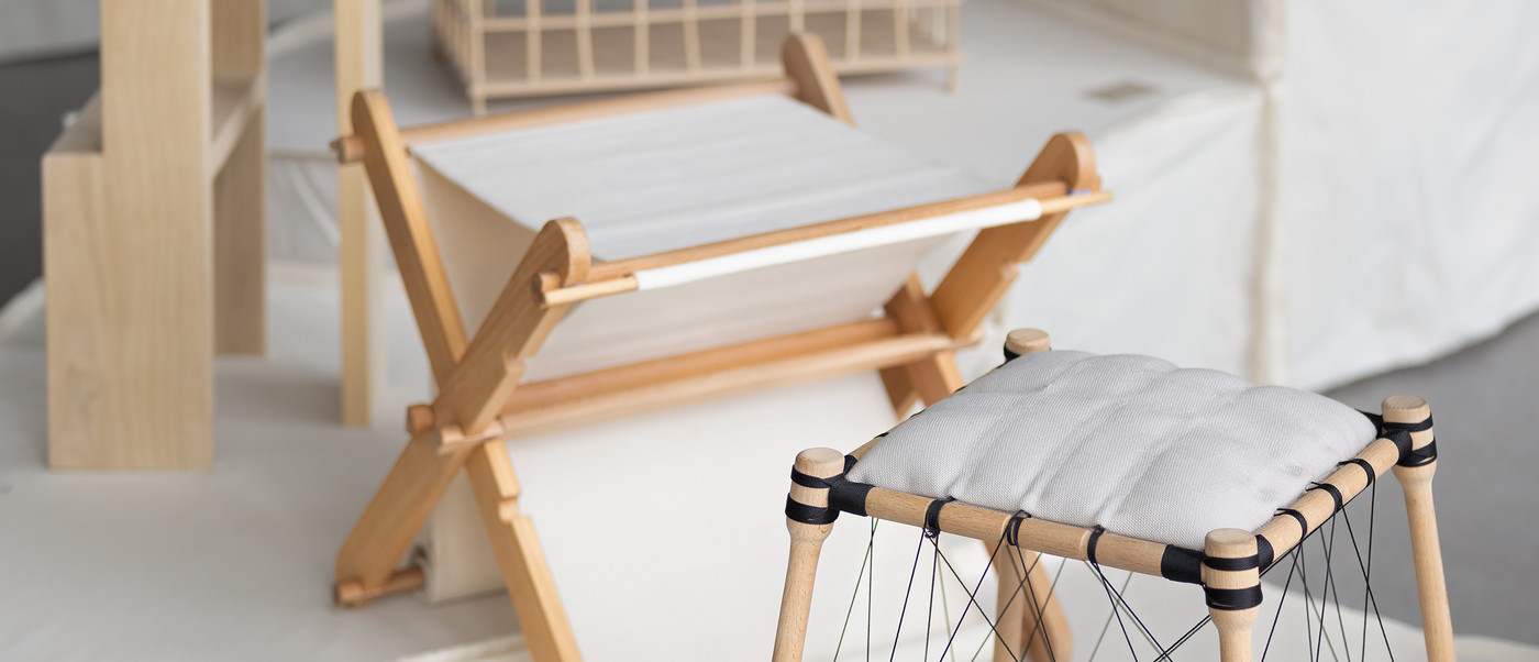 Wooden furniture prototypes and architectural model on display.