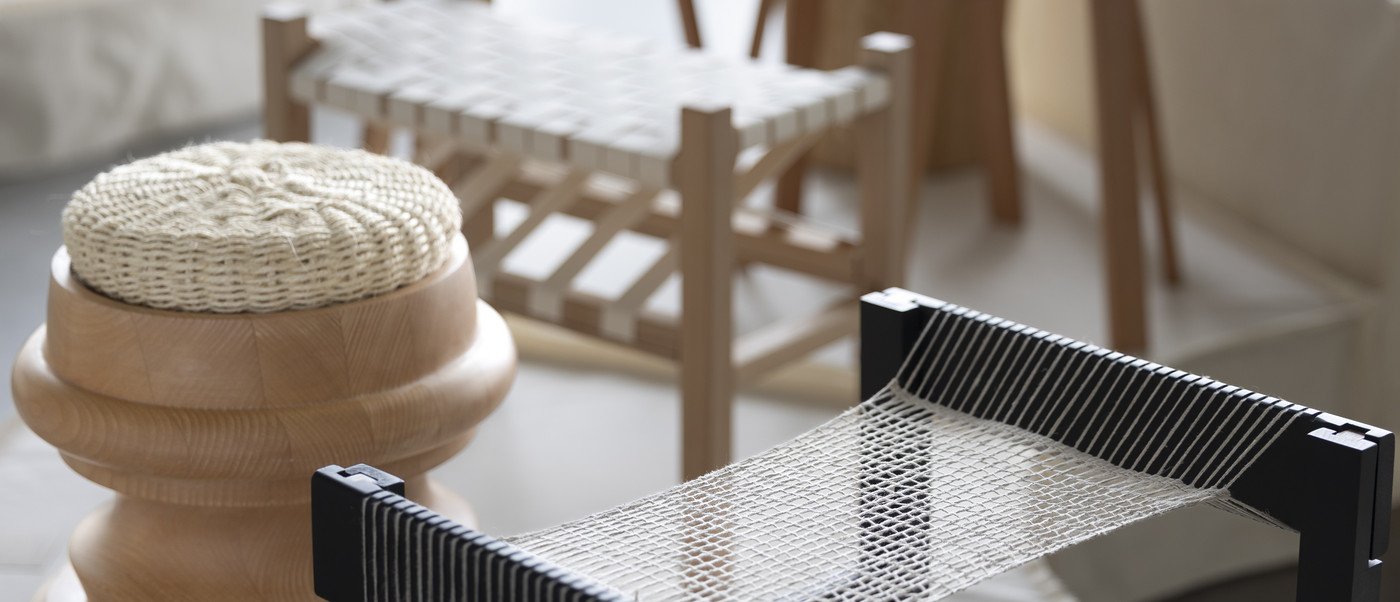Woven stool and textile chair detail in exhibition.