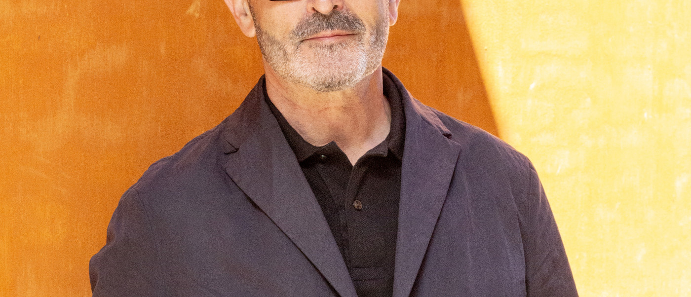 Nicholas Rhodes in front of ochrecolored wall