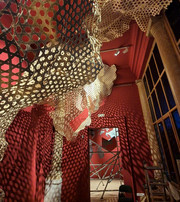 Red room with weaved structure expanded from the ceiling and on walls