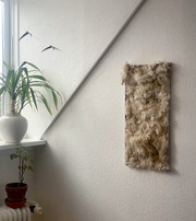 Wool panel hanging on wall in interior.