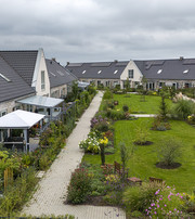 Boligområde med rækkehuse omkring fælles grøn gård med stier, beplantning og opholdsarealer