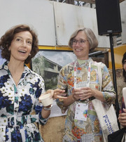  Three people conversing at an exhibition with architectural images.
