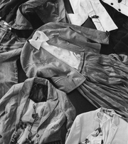 Assorted jackets, shirts and trousers arranged in an overlapping composition.
