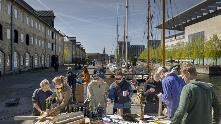 Studerende arbejder med træ på kaj