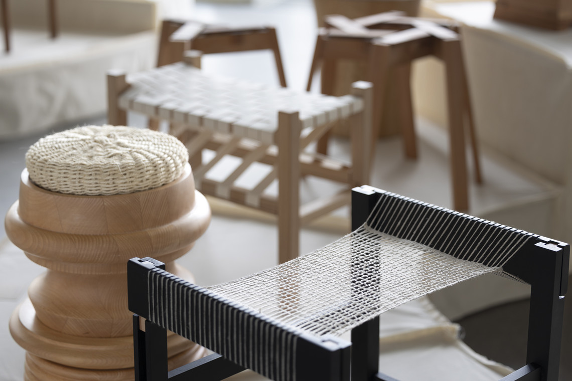 Woven stool and textile chair detail in exhibition.