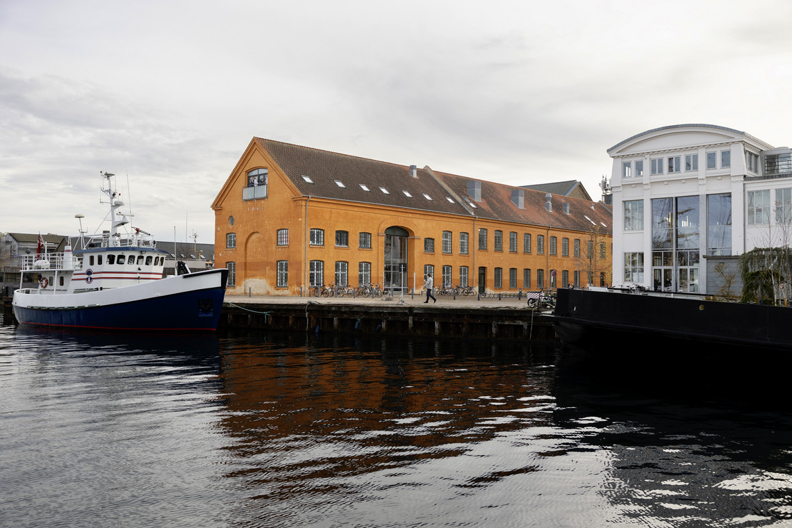 Harbor with boat and orange industrial building.