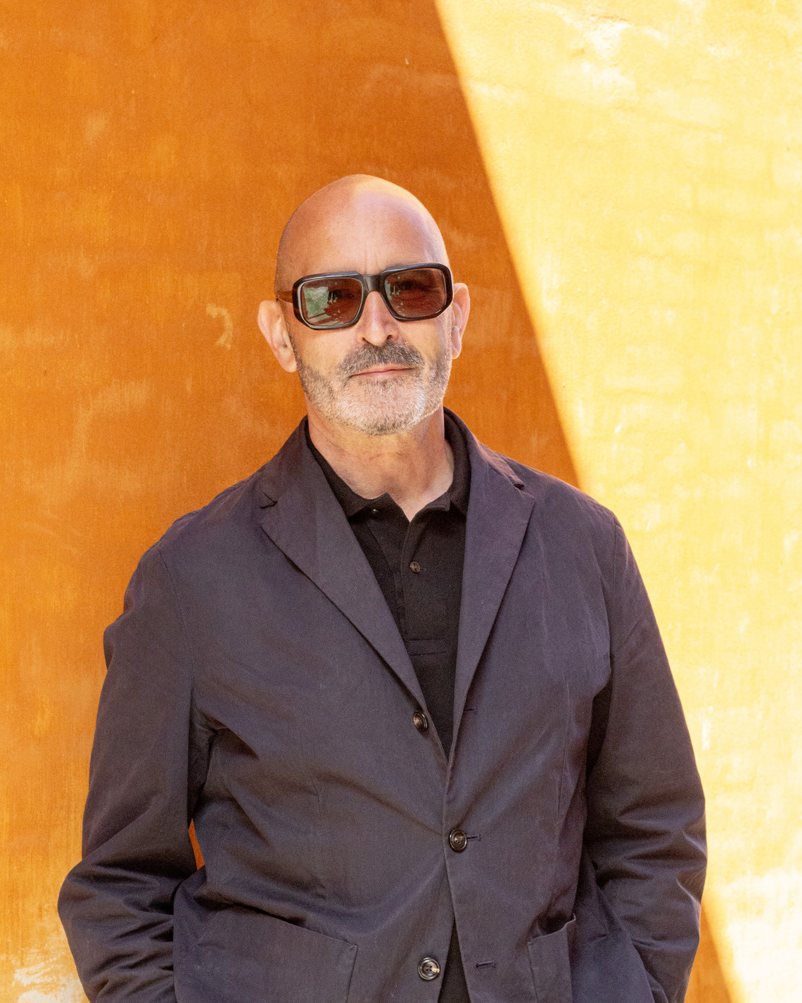 Nicholas Rhodes in front of ochrecolored wall