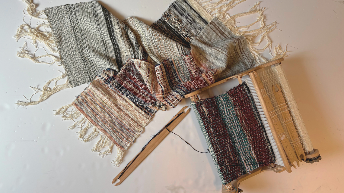 Handwoven textile samples next to a loom