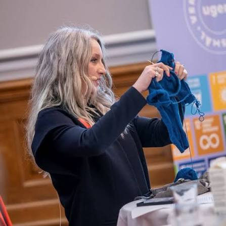 Researcher standing in the danish pairlament, holding a piece of clothing