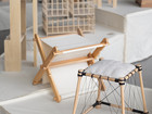 Wooden furniture prototypes and architectural model on display.