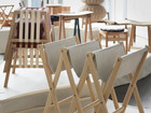 Foldable wooden chairs displayed on an exhibition platform.
