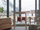 Wooden stool and small furniture pieces by a window.