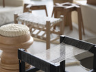 Woven stool and textile chair detail in exhibition.