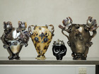 Decorative ceramic vases displayed on a metal shelf.