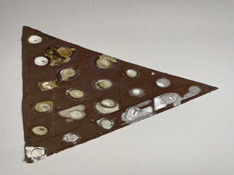 A picture of a triaxal-blend. Three different materials are used to develop a simple, transparent glaze. Tested on red clay.