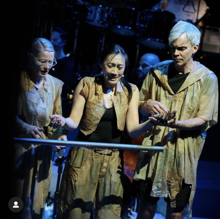 Two women and one man dressed in yellowish clothing