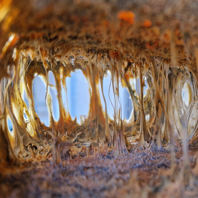 Interior view of a hollow structure with thread-like golden textures.