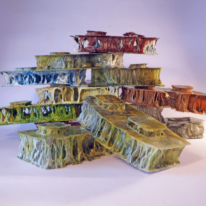 Stack of colored, hollow structures in various shades.