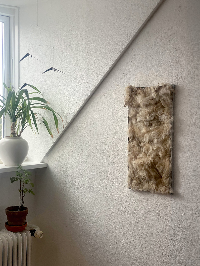 Wool panel hanging on wall in interior.
