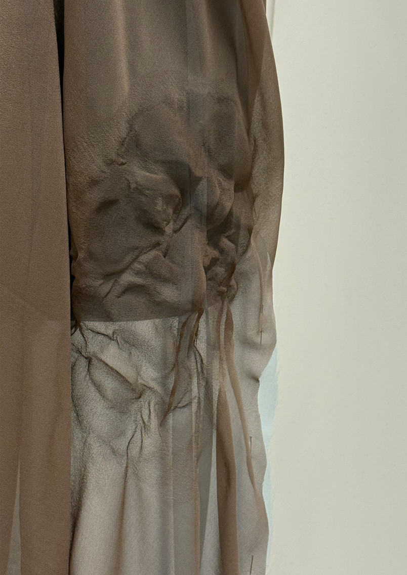 Close-up detail of relief-like Luohan faces created on lightweight silk fabric, suggesting different inner emotions and states carried within the body.