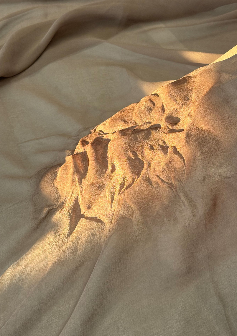 Close-up detail of relief-like Luohan faces created on lightweight silk fabric, suggesting different inner emotions and states carried within the body.