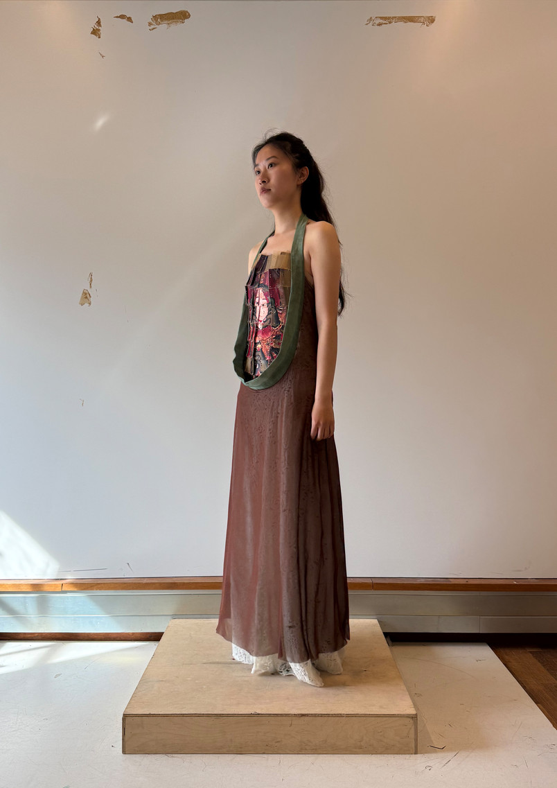 Model wearing a soft flowing garment with an armour-inspired surface featuring the motif of the Face-Tearing Wisdom King, symbolically tearing open anger to reveal calm beneath.
