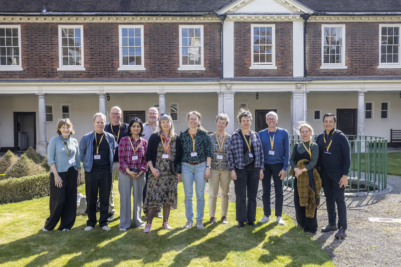 Group of people standing in a courtyard in front of a historic building