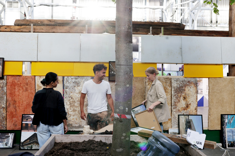 Three people laughing together whilst setting up a pavilion 