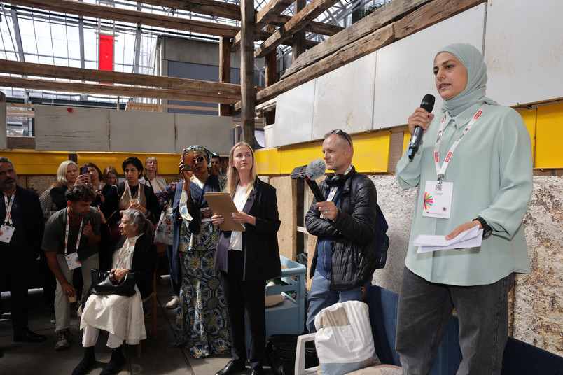Woman speaking in front of group of people