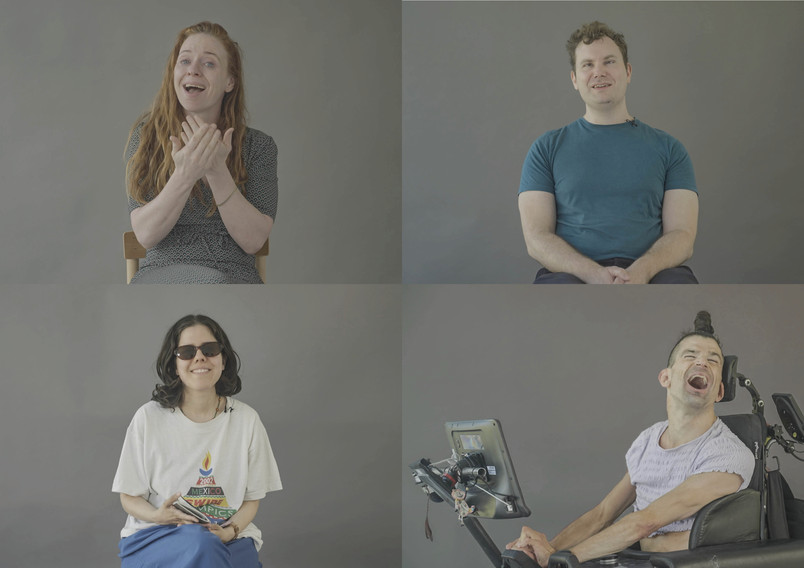 Four people with different expressions are sitting in front of a grey background, including a man in a wheelchair.