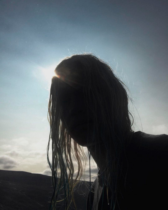 strong backlight, a human by a waterfall