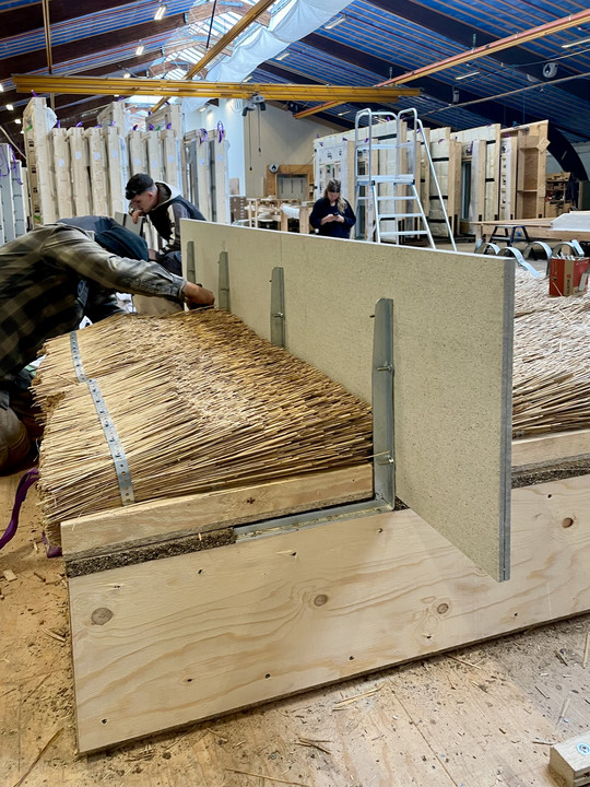 Reed thatch against vertical panels.