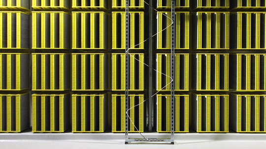 A large white data center with server racks and overhead cable management.