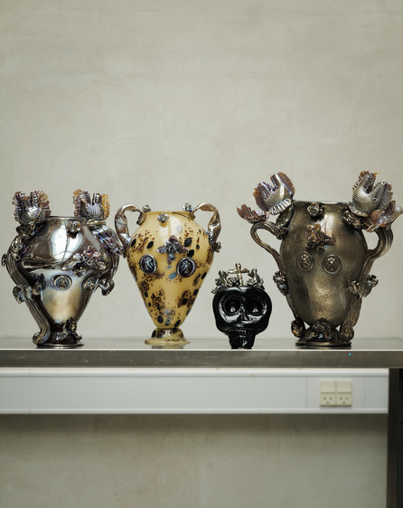 Decorative ceramic vases displayed on a metal shelf.