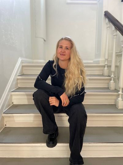 Person sitting on a staircase in a bright stairwell, portrait.