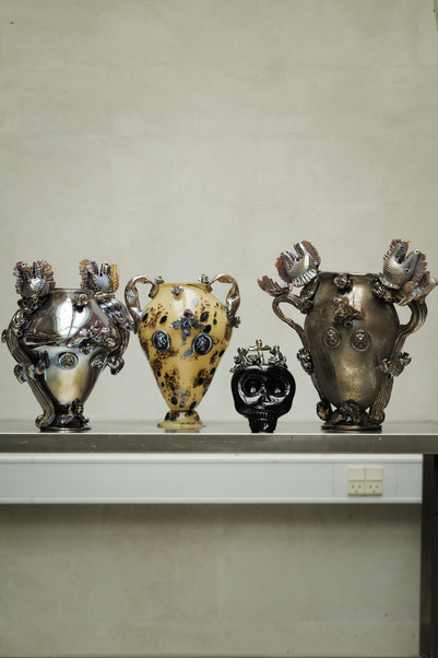 Decorative ceramic vases displayed on a metal shelf.