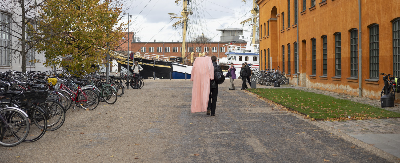 to mennesker, skib i baggrunden, orange bygning til højre