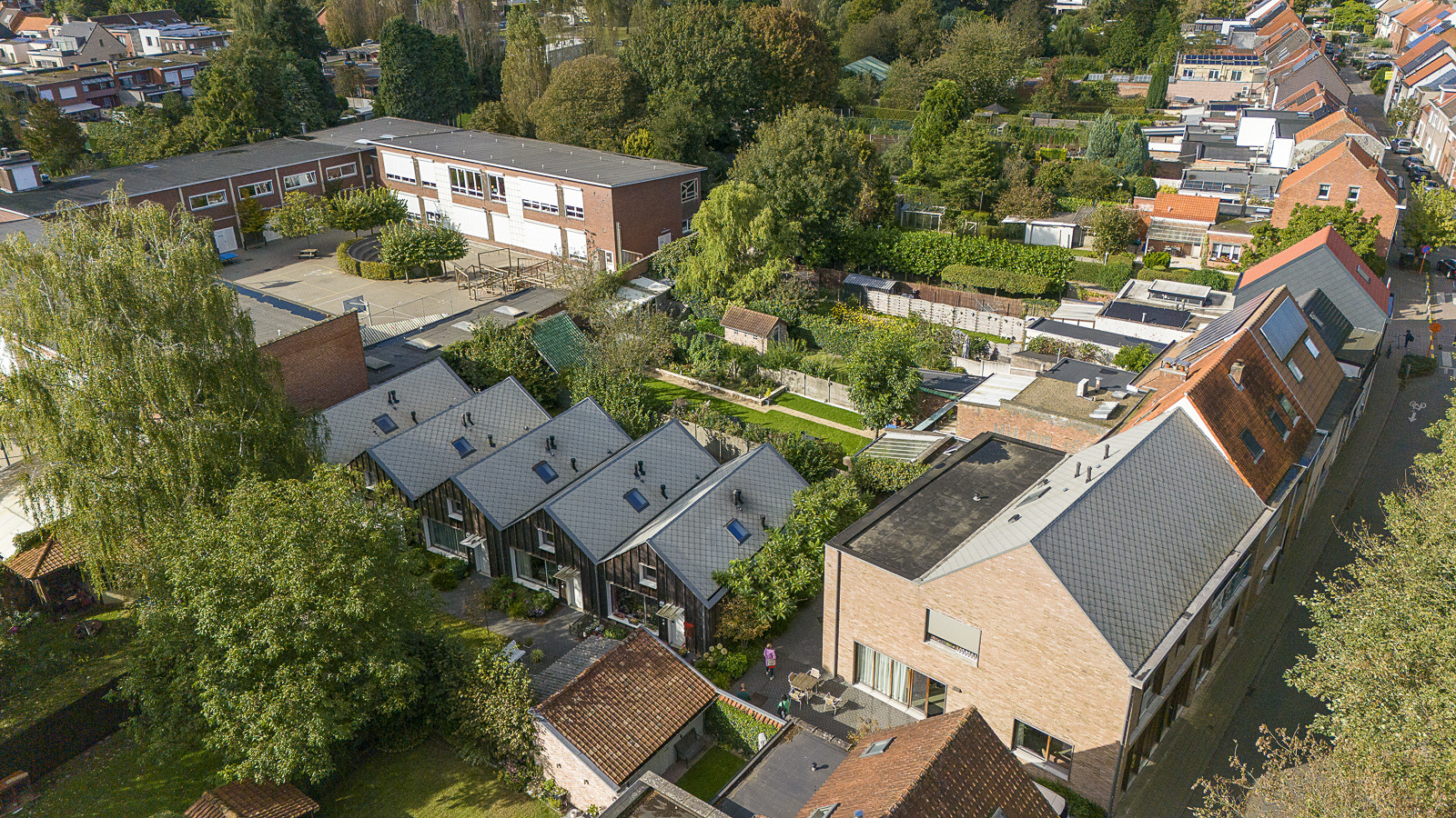 Aerial view of housing area with small homes, gardens, and shared spaces