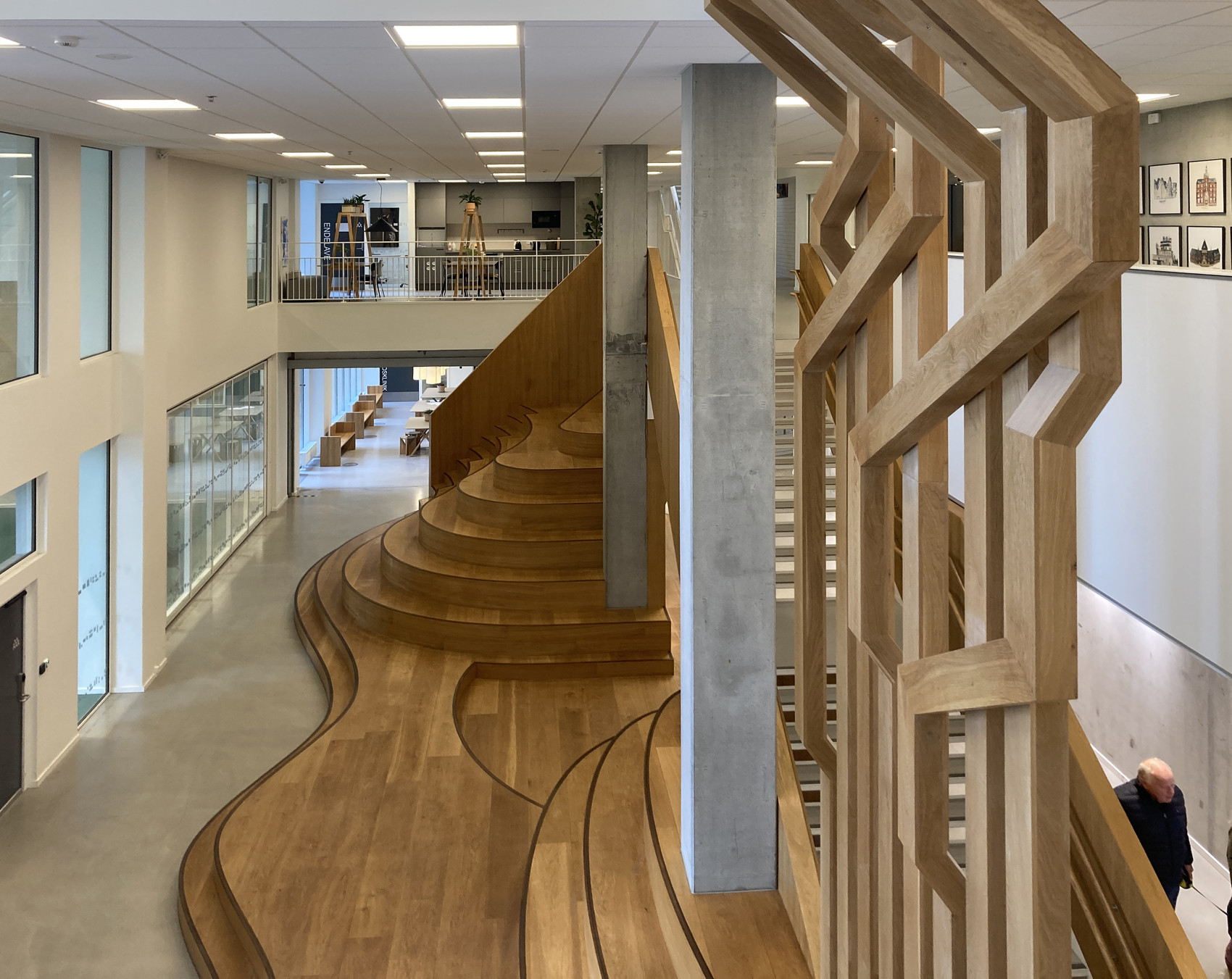 Moderne indendørs atrium med trappe i træ og åbne etager